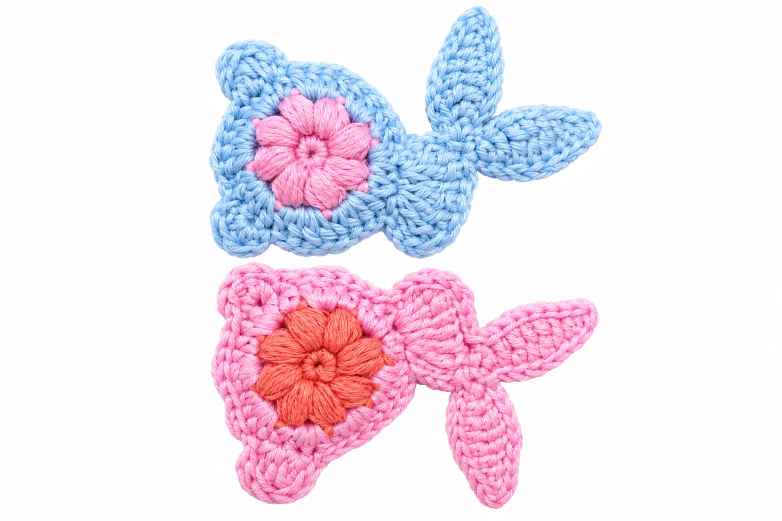 Zwei kleine Fische in Blau und Rosa mit blütenförmigen Details. Ansicht 1.