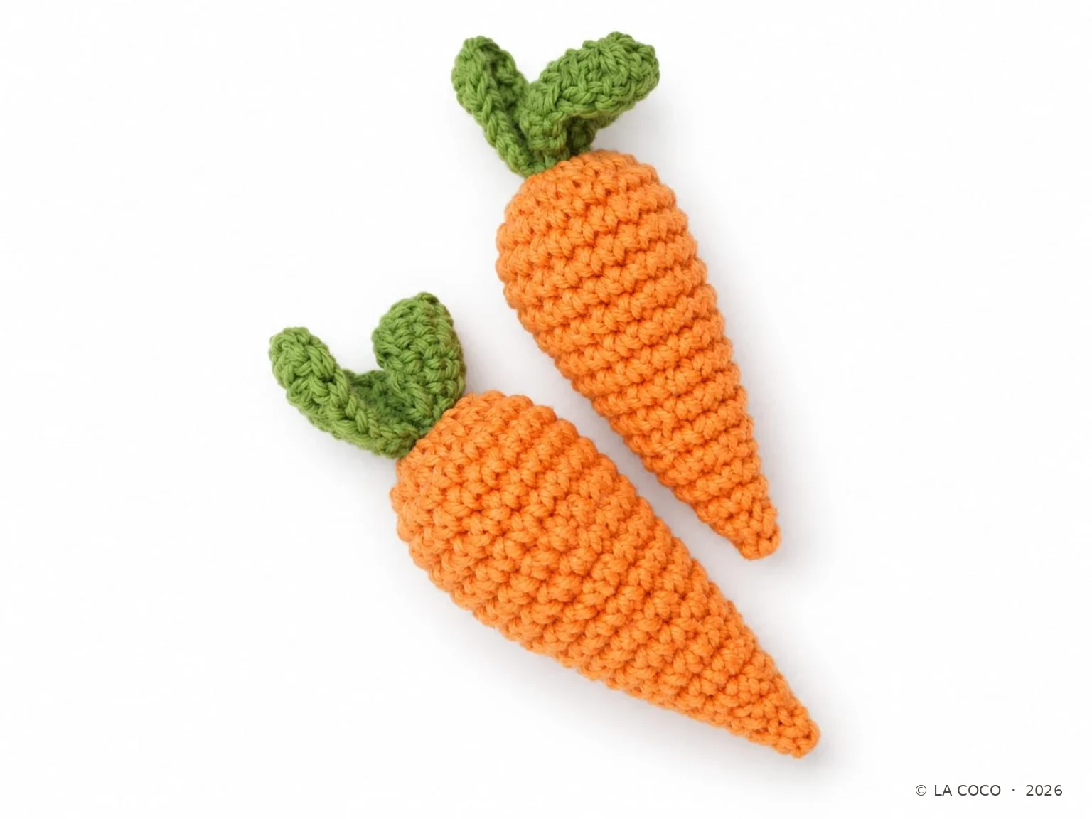 Kinderküche – Zwei orangefarbene Häkelkarotten mit grünem Blattgrün