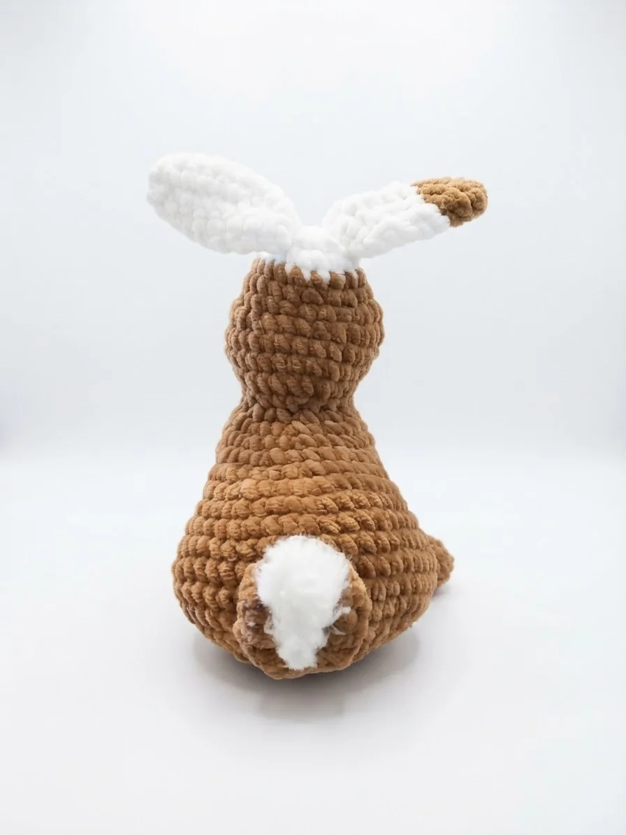 Ein brauner Hase mit langen hellen Ohren und kleinem weißem Schwänzchen. Ansicht 3.