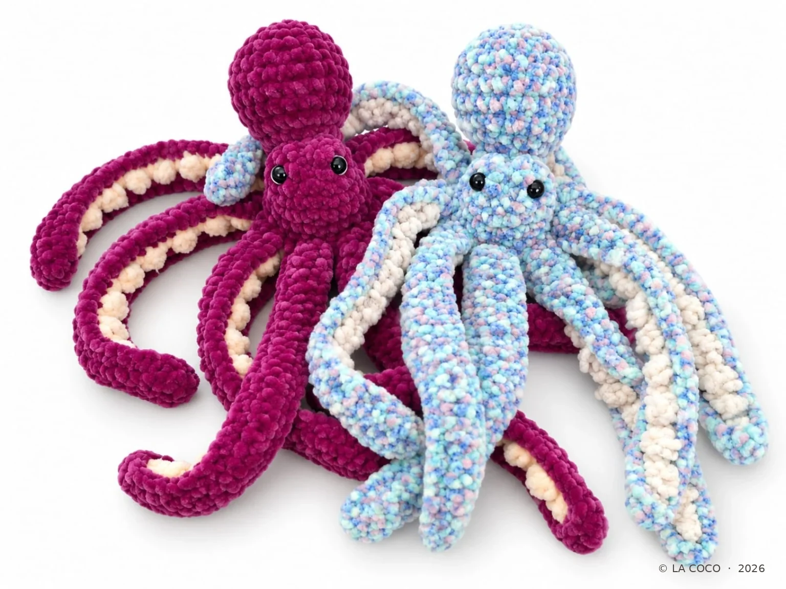 Zwei gehäkelte Oktopusse in Magenta und Pastellblau