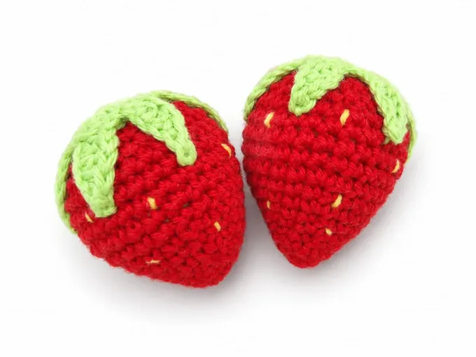 Kinderküche – Zwei rote gehäkelte Erdbeeren mit grünen Blättern
